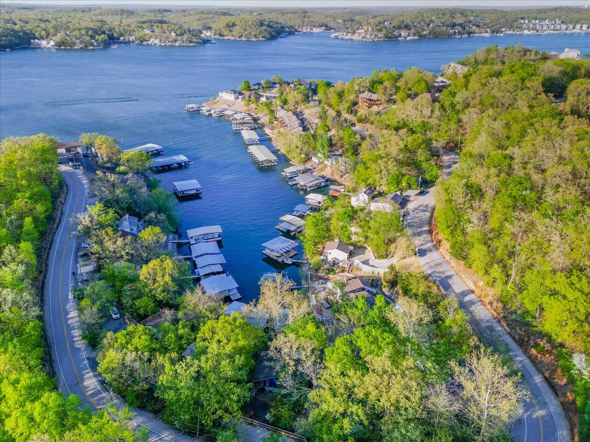 A broad waterfront scene showing a lake with docks, homes lining the shore, and dense trees. The view highlights the expansive waterway and active docks, which are ideal for launching boats, fishing, and exploring the coves described in the section.