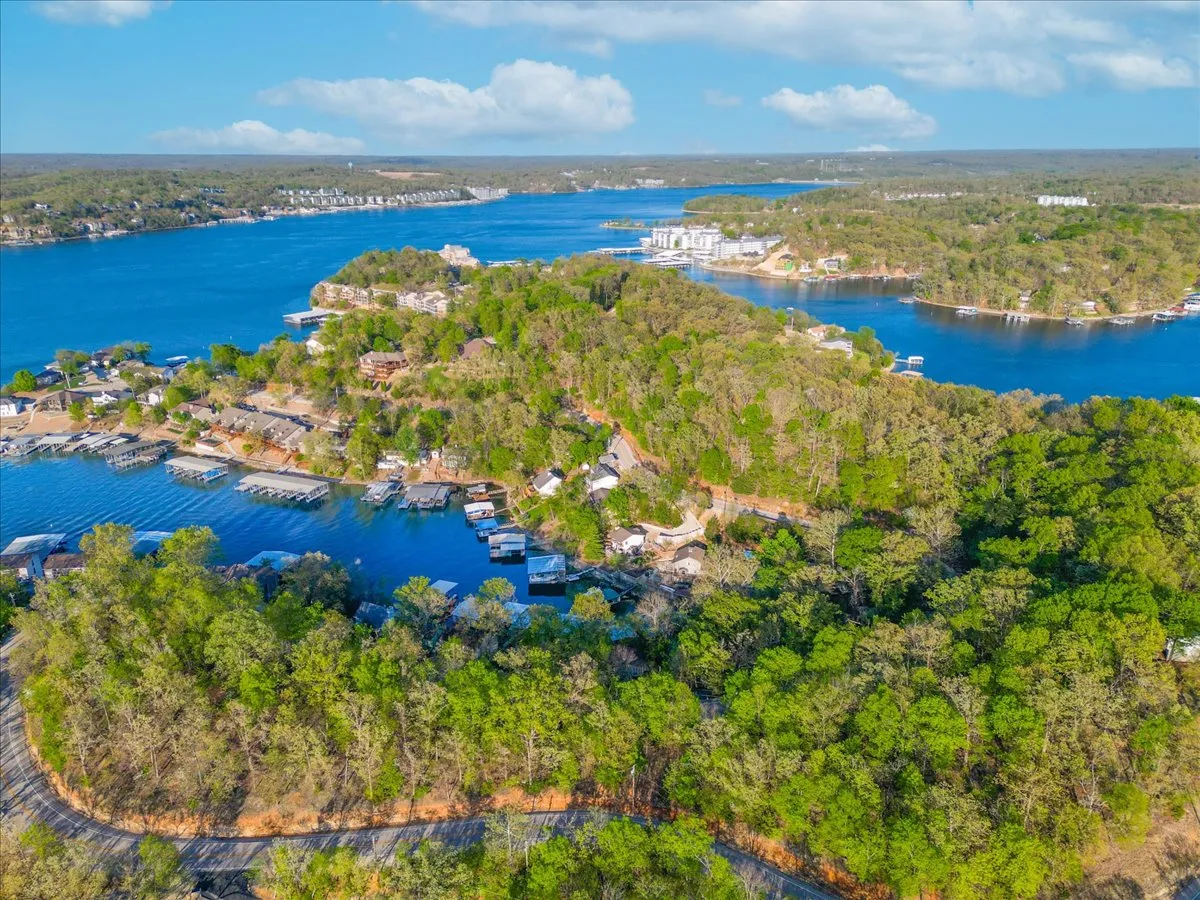 A picturesque lake scene with serene blue water, lush green trees, waterfront houses, and marinas filled with boats. The tranquil setting is ideal for sunset boat rides, fishing excursions, and scenic paddling as described in the section.