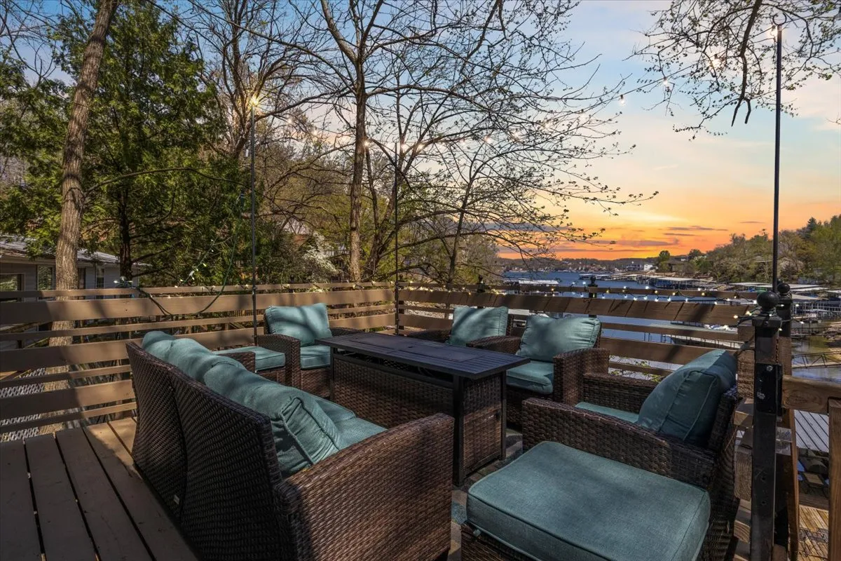 This exterior shot highlights a stylish outdoor seating area overlooking a waterfront at sunset. The tranquil vibe and comfortable furniture make it an ideal spot for intimate gatherings or winding down after a night out.